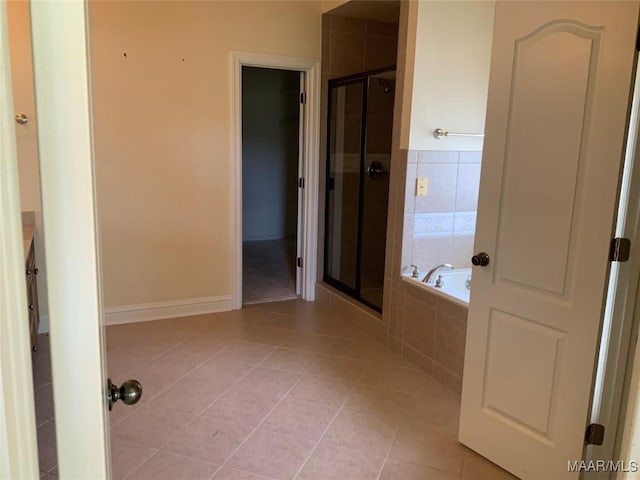 bathroom featuring tile patterned floors, a stall shower, and a garden tub