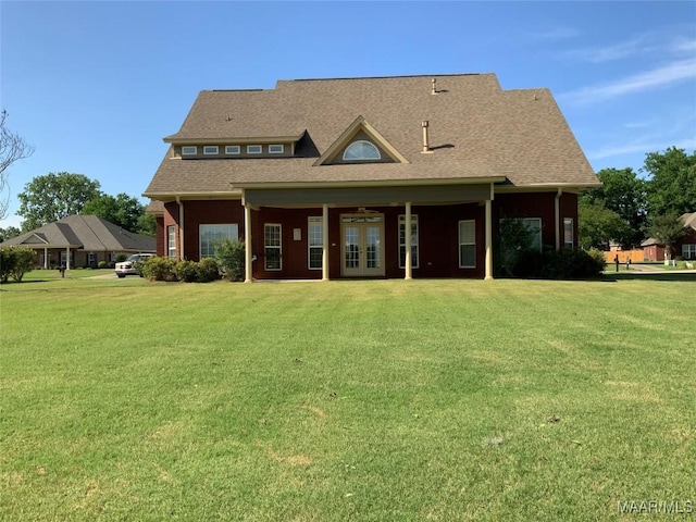 back of house with a lawn, roof with shingles, and french doors