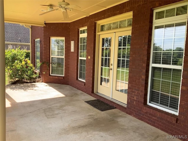 property entrance featuring french doors, a patio area, brick siding, and a ceiling fan