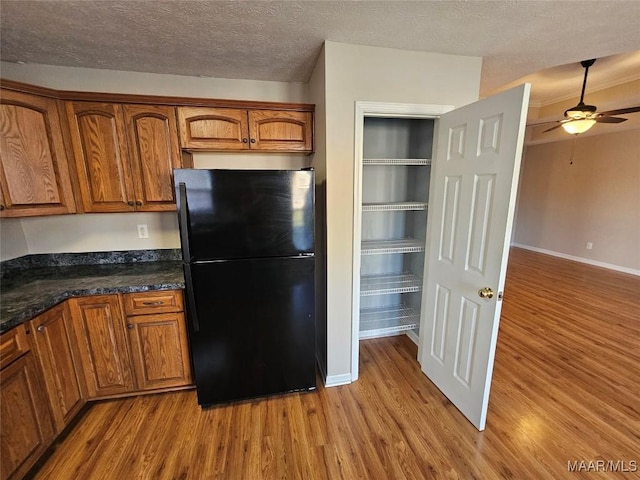 1946 Regent Rd, Prattville, AL 36066 - kitchen with brown cabinets, freestanding refrigerator, a textured ceiling, ceiling fan, and light wood-style floors