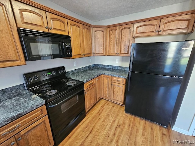 1946 Regent Rd, Prattville, AL 36066 - kitchen featuring brown cabinetry, black appliances, light wood-style flooring, and a textured ceiling