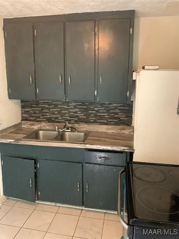 341 Chisholm St, Montgomery, AL 36110 - kitchen with black range with electric stovetop, a sink, decorative backsplash, and light tile patterned floors