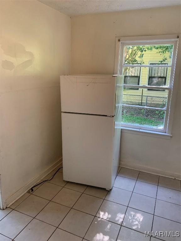 341 Chisholm St, Montgomery, AL 36110 - kitchen with freestanding refrigerator, healthy amount of natural light, and light tile patterned flooring