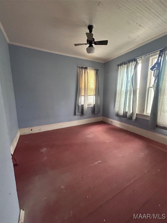 empty room featuring baseboards, crown molding, and a ceiling fan