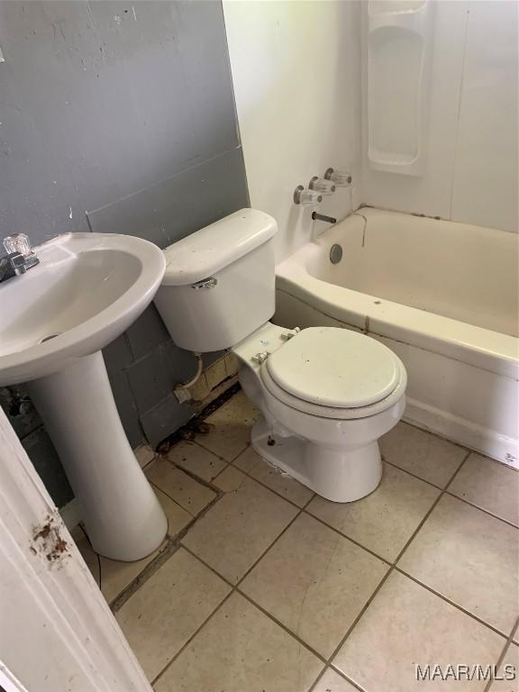 full bathroom featuring toilet, tile patterned floors, and a sink