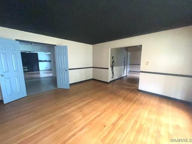 spare room with wood finished floors and baseboards