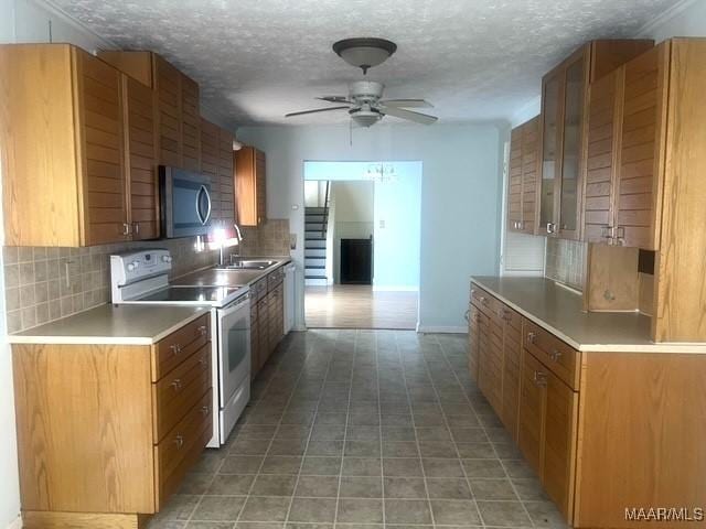kitchen featuring white electric range, stainless steel microwave, backsplash, a sink, and a ceiling fan