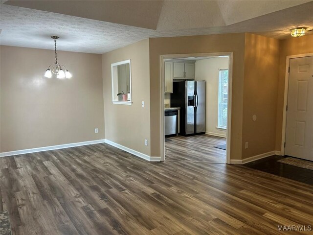1348 Whisperwood Ct, Montgomery, AL 36117 - unfurnished dining area featuring dark wood-style floors, baseboards, a textured ceiling, and a chandelier