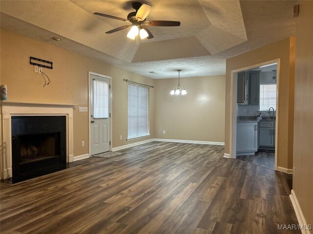 1348 Whisperwood Ct, Montgomery, AL 36117 - unfurnished living room with a tray ceiling, dark wood finished floors, a sink, a chandelier, and baseboards