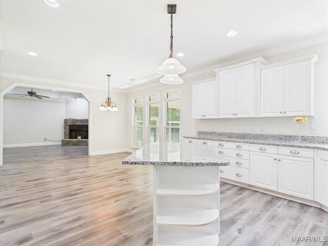 175 Rosemere Dr, Tallassee, AL 36078 - kitchen featuring a fireplace, open shelves, crown molding, white cabinets, and decorative light fixtures