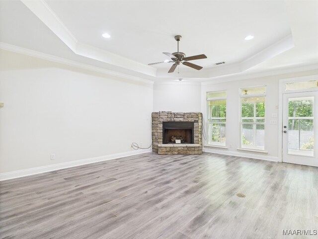 175 Rosemere Dr, Tallassee, AL 36078 - unfurnished living room with a tray ceiling, a stone fireplace, crown molding, ceiling fan, and wood finished floors