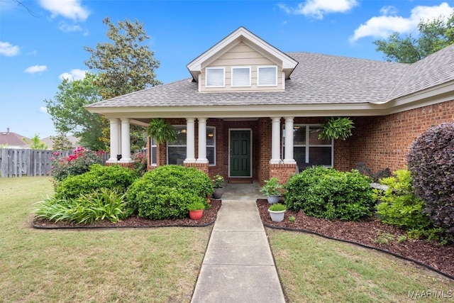 view of front of home featuring brick siding, roof with shingles, and covered porch
