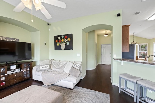 living room with arched walkways, ceiling fan, wood finished floors, vaulted ceiling, and baseboards