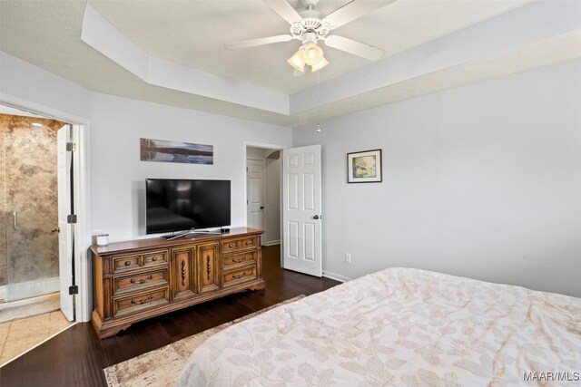 bedroom with wood finished floors, a raised ceiling, a ceiling fan, and baseboards