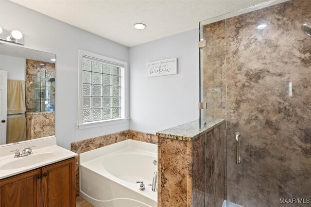 full bathroom with a bath, a shower stall, and vanity