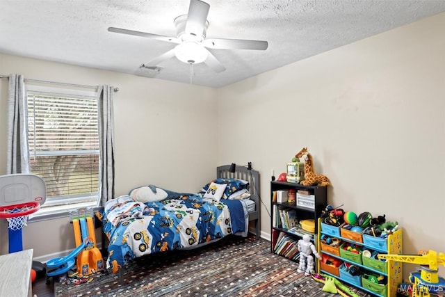 bedroom featuring multiple windows, a textured ceiling, baseboards, a ceiling fan, and carpet