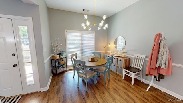dining room with wood finished floors, a chandelier, and baseboards