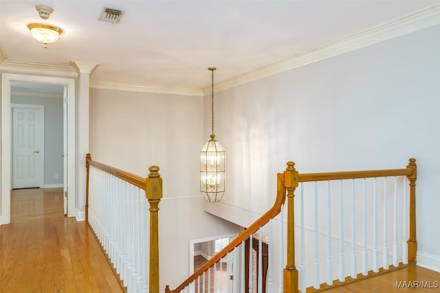 8180 Longneedle Pl, Montgomery, AL 36117 - hallway featuring an upstairs landing, a chandelier, wood finished floors, ornamental molding, and baseboards