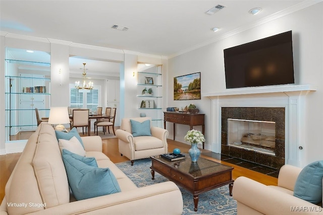 8180 Longneedle Pl, Montgomery, AL 36117 - living room featuring a chandelier, ornamental molding, wood finished floors, built in shelves, and a tiled fireplace