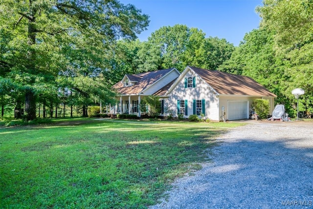 new england style home featuring gravel driveway, an attached garage, a front lawn, and covered porch