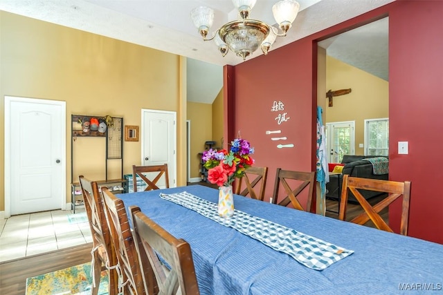 dining room with high vaulted ceiling, a chandelier, wood finished floors, and baseboards