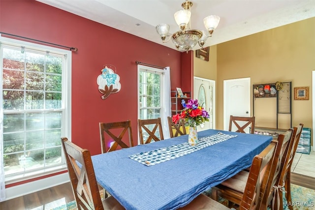 dining space with a chandelier, healthy amount of natural light, and wood finished floors