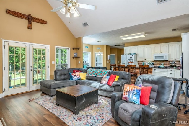 living area featuring high vaulted ceiling, wood finished floors, a ceiling fan, and french doors