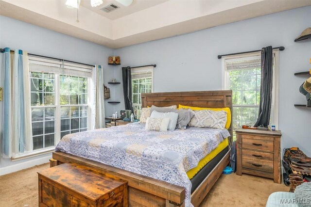bedroom featuring light colored carpet and multiple windows
