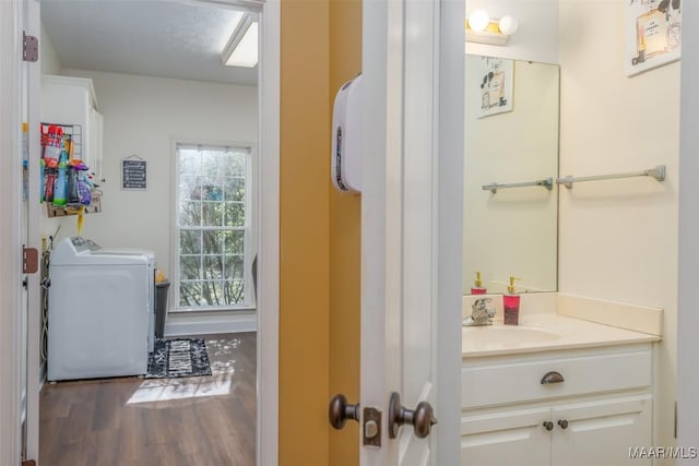 bathroom featuring washer / clothes dryer, wood finished floors, and vanity