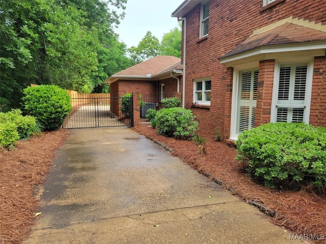 1550 Meriwether Rd, Montgomery, AL 36117 - view of side of home with a gate, brick siding, roof with shingles, and cooling unit