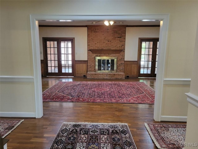 1550 Meriwether Rd, Montgomery, AL 36117 - unfurnished living room with wood finished floors, a brick fireplace, wainscoting, healthy amount of natural light, and baseboards