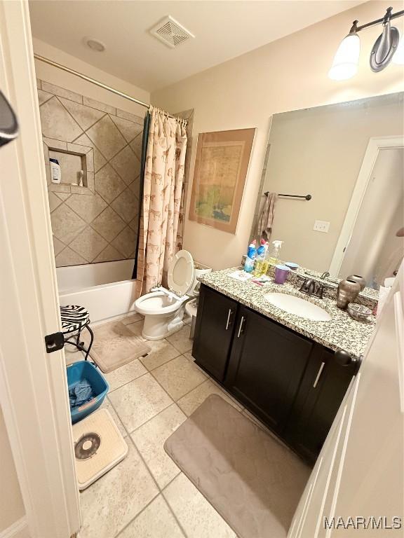 full bath featuring tile patterned flooring, toilet, vanity, and shower / tub combo