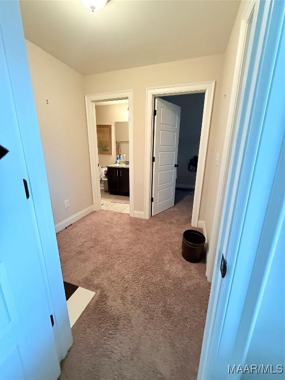 hall with carpet flooring and baseboards