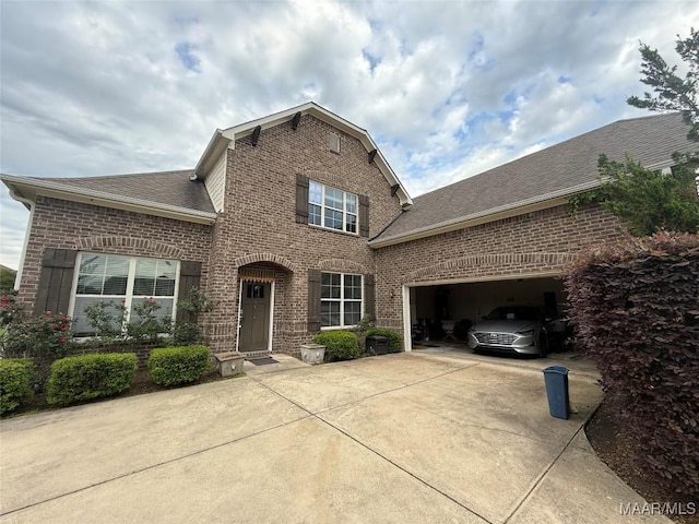 traditional-style house featuring brick siding, a shingled roof, concrete driveway, and a garage