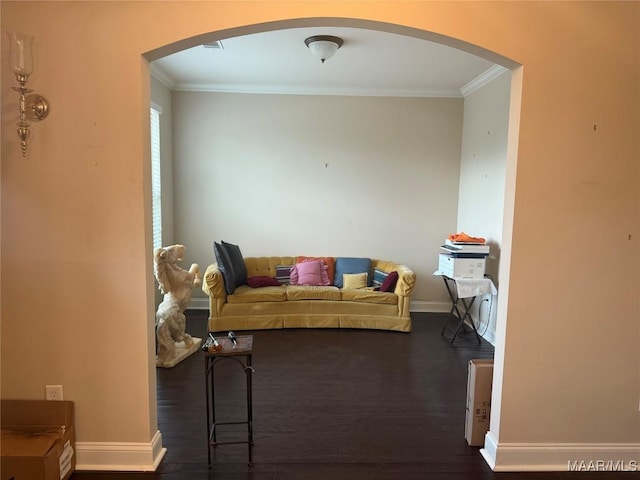 living area featuring arched walkways, ornamental molding, dark wood-style floors, and baseboards