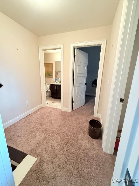 corridor with light colored carpet and baseboards