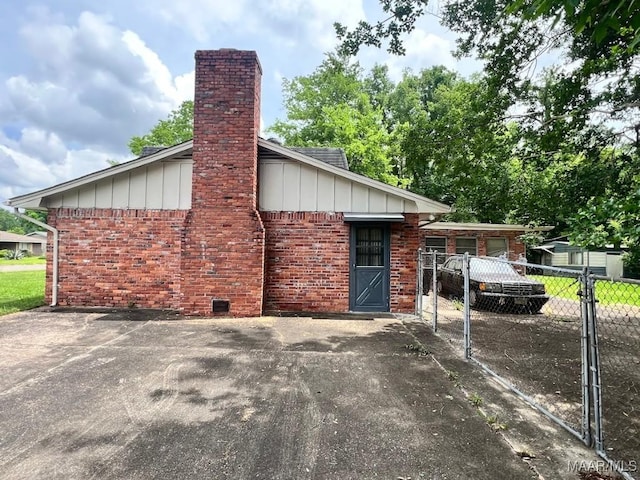 3600 Hunting Creek Rd, Montgomery, AL 36116 - rear view of property with board and batten siding, brick siding, fence, and a chimney