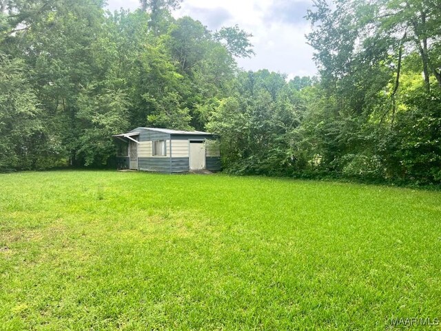3600 Hunting Creek Rd, Montgomery, AL 36116 - view of grassy yard with an outdoor structure, a forest view, and a shed