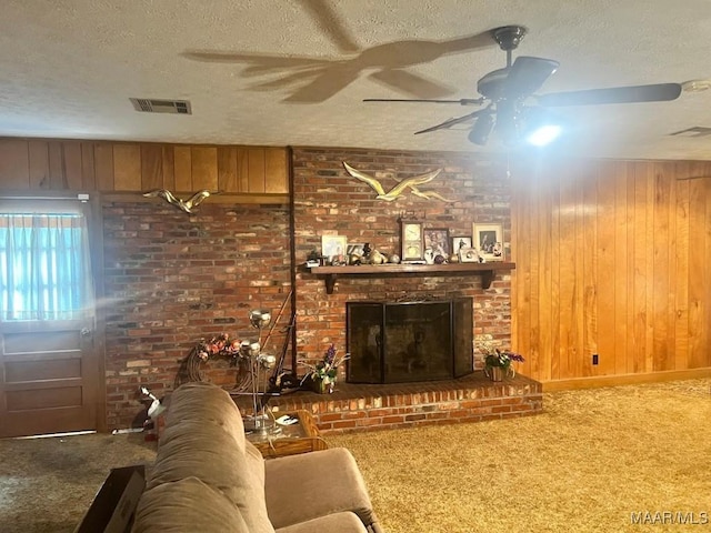 3600 Hunting Creek Rd, Montgomery, AL 36116 - living area with carpet, ceiling fan, a textured ceiling, a brick fireplace, and wood walls