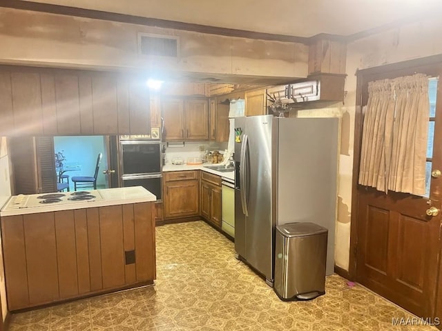 3600 Hunting Creek Rd, Montgomery, AL 36116 - kitchen featuring appliances with stainless steel finishes, light floors, light countertops, and brown cabinetry