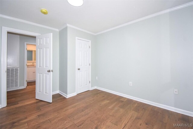 6790 Upper River Rd, Tallassee, AL 36078 - unfurnished bedroom with dark wood-type flooring, baseboards, crown molding, and a closet