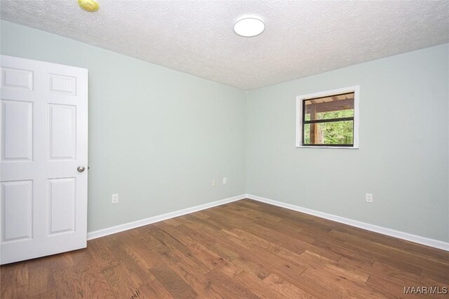 6790 Upper River Rd, Tallassee, AL 36078 - unfurnished room featuring dark wood-style flooring, a textured ceiling, and baseboards