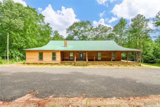 6790 Upper River Rd, Tallassee, AL 36078 - chalet / cabin featuring covered porch, metal roof, and a chimney