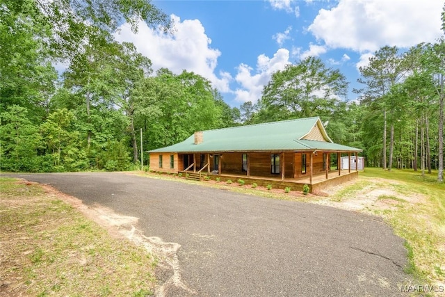 6790 Upper River Rd, Tallassee, AL 36078 - view of front of house with a porch, driveway, metal roof, and a view of trees