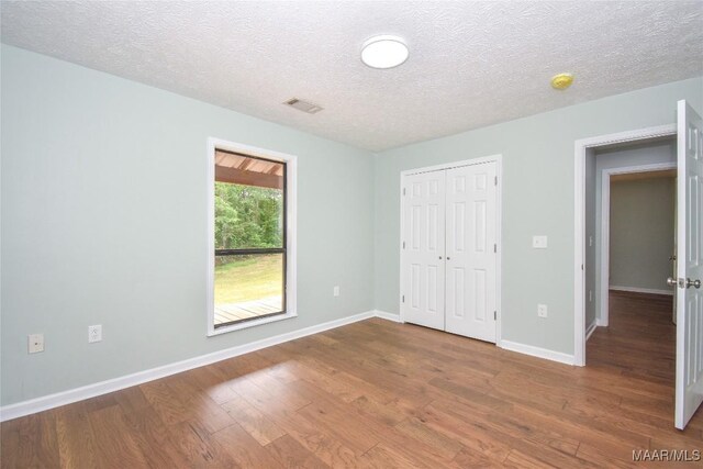 6790 Upper River Rd, Tallassee, AL 36078 - unfurnished bedroom with wood finished floors, baseboards, a closet, and a textured ceiling