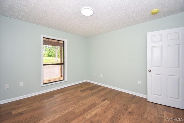 6790 Upper River Rd, Tallassee, AL 36078 - unfurnished room featuring dark wood-type flooring, a textured ceiling, and baseboards