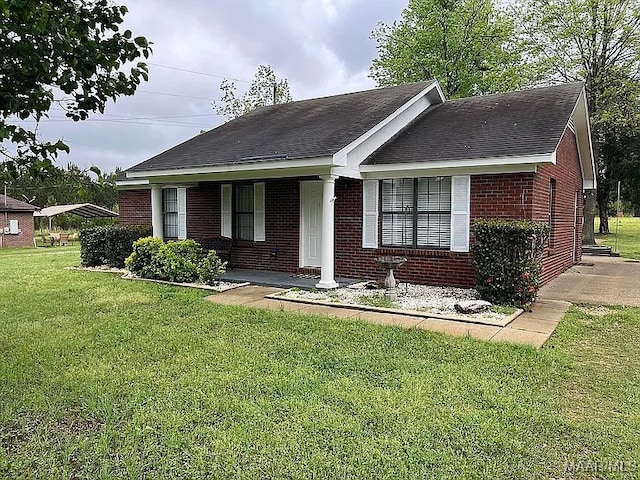 ranch-style home featuring brick siding, a front yard, a porch, and a shingled roof