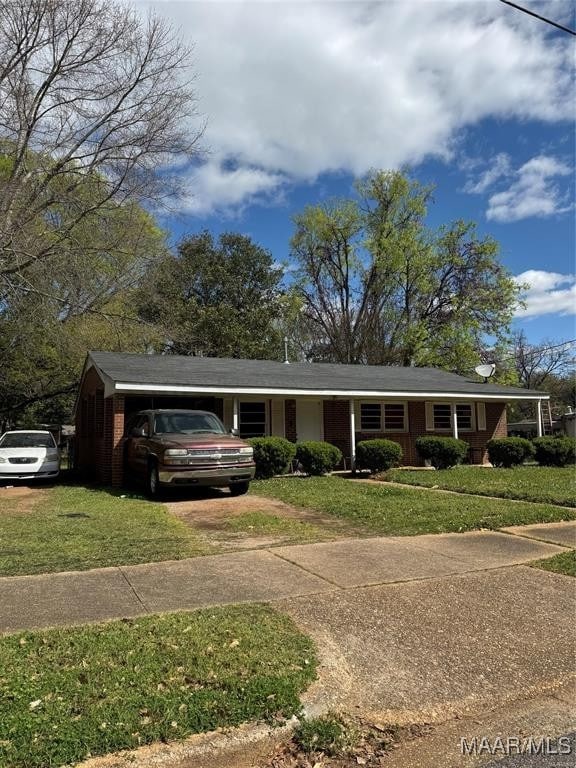 ranch-style house featuring a front yard and driveway