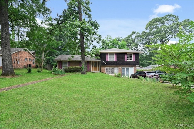 view of front facade featuring a front lawn, french doors, and brick siding