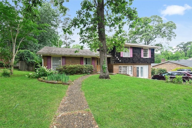 tri-level home with brick siding, a front yard, and french doors